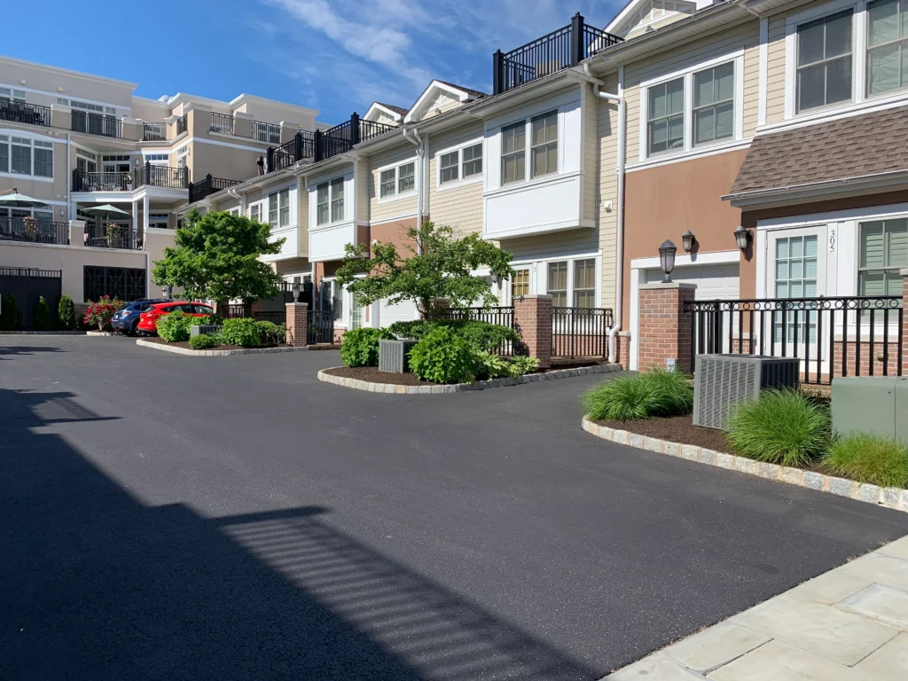 Row of modern townhomes with beigewhite siding balconies and large windows under a blue sky Readable details clean suburban housing complex